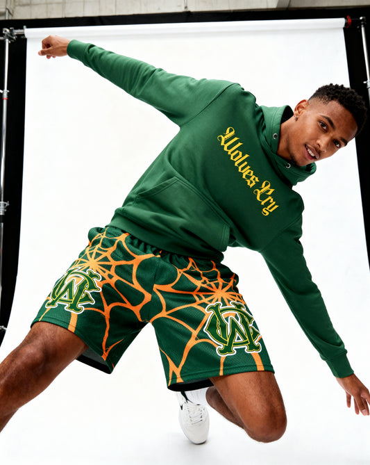 Model wearing Wolves Cry OG Green & Gold Spider Web mesh shorts — relaxed fit, movement-ready street athletic style.