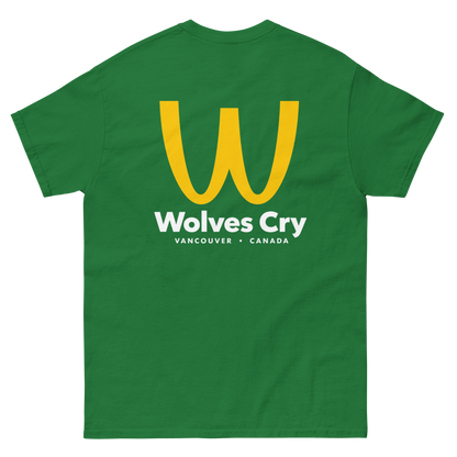 A green short-sleeve t-shirt with a large yellow 'W' logo and white text reading 'Wolves Cry' and 'VANCOUVER • CANADA' on the front, shown against a plain white background. McDowells restaurant tee shirt, coming to America parody bootleg 