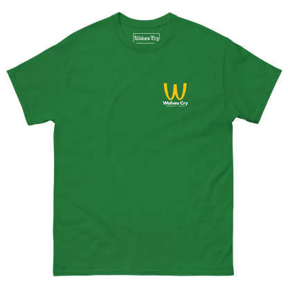 A green short-sleeve crewneck t-shirt with a small yellow and white 'Wolves Cry' logo printed on the left chest, displayed on a clean white background. McDowells restaurant tee shirt, coming to America.