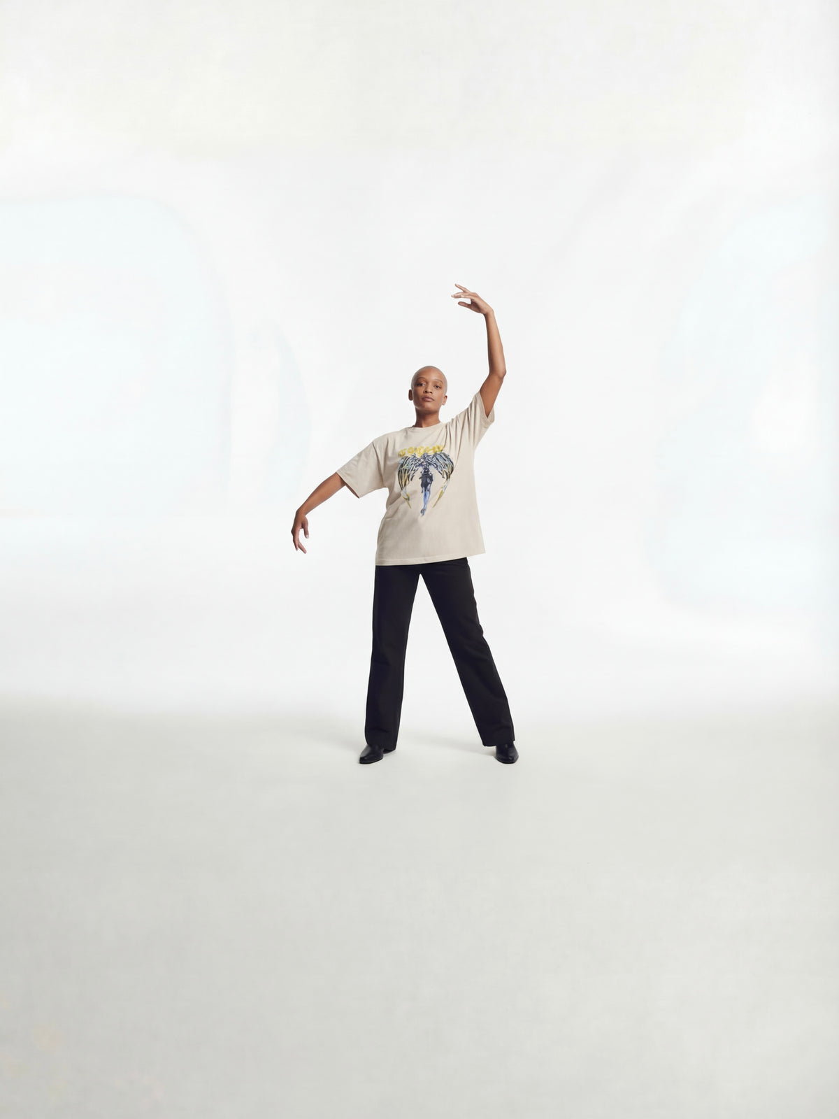 Model in motion wearing Wolves Cry Originals Angels oversized tee in bone demonstrating movement, oversized fit, and heavyweight streetwear construction.