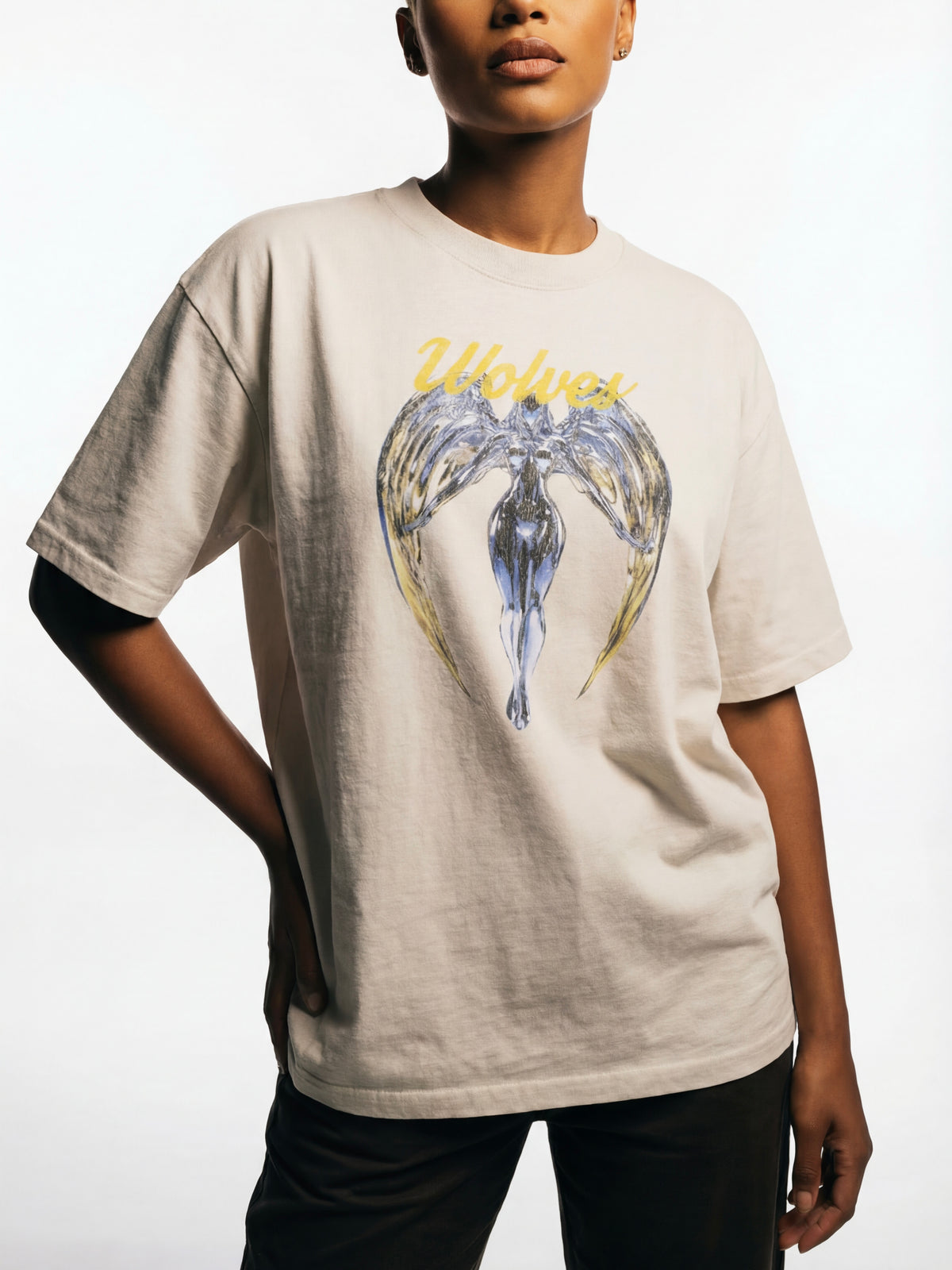 Model wearing the Wolves Cry Originals Angels oversized tee in bone photographed in studio lighting highlighting the heavyweight cotton and oversized streetwear fit.