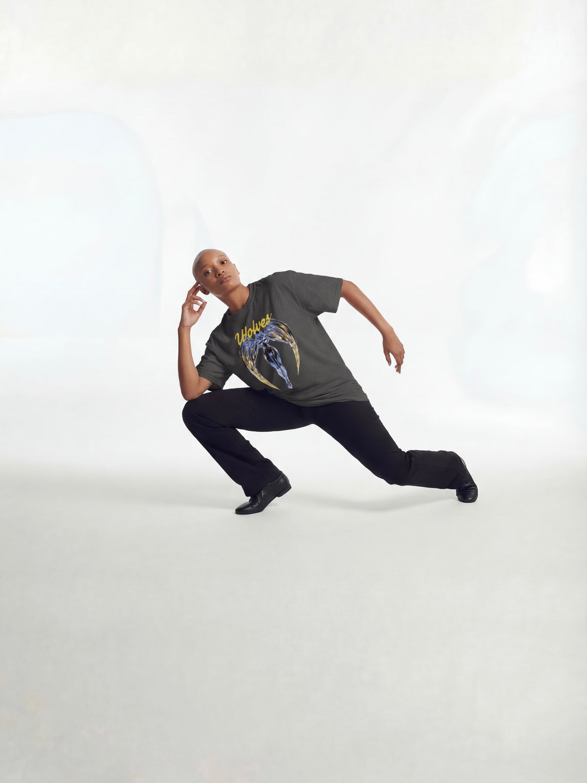 Wolves cry angels oversized tee shirt, modeled in dancer pose,  wearing a graphic t-shirt and black pants on a white background