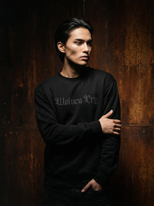 Man wearing a black sweatshirt with text against a dark background