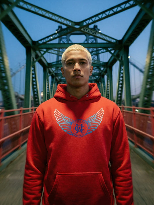 Person wearing a red hoodie with a logo on a bridge