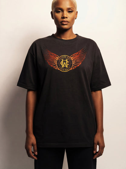 Person wearing a black t-shirt with a logo on a plain background