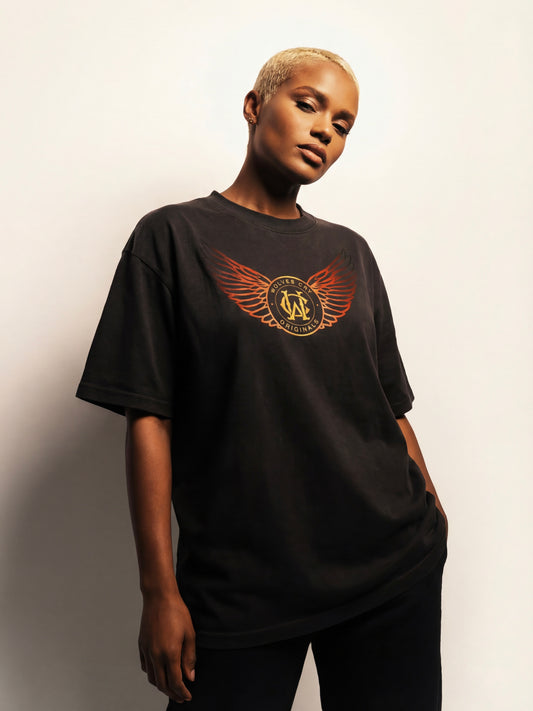 Person wearing a black t-shirt with a logo on a plain background