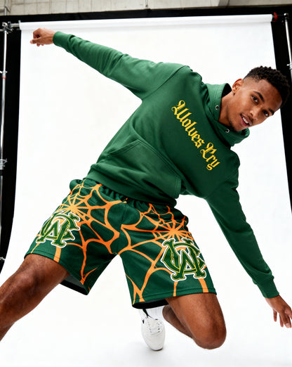 Model wearing Wolves Cry OG Green & Gold Spider Web mesh shorts — relaxed fit, movement-ready street athletic style.